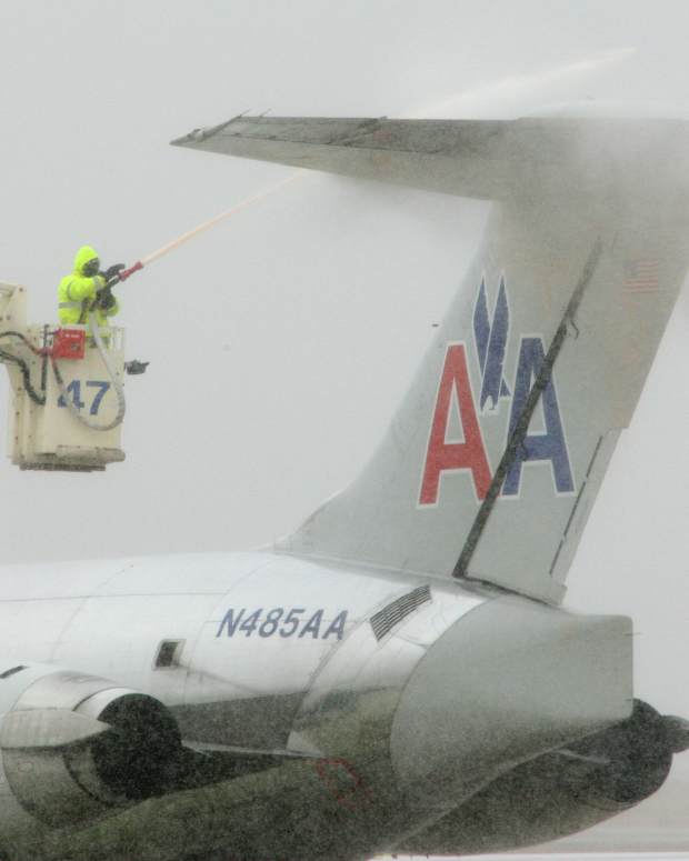 A storm moves across North Texas bringing heavy winds and snow. Ground crews de-ice an American Airlines jet at Dallas/Fort Worth Airport on Thursday, December 24, 2009.  (Photo by Paul Moseley/Fort Worth Star-Telegram/Tribune News Service via Getty Images)