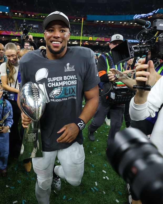 Saquon Barkley celebrates with the Vince Lombardi Trophy after winning Super Bowl 59.