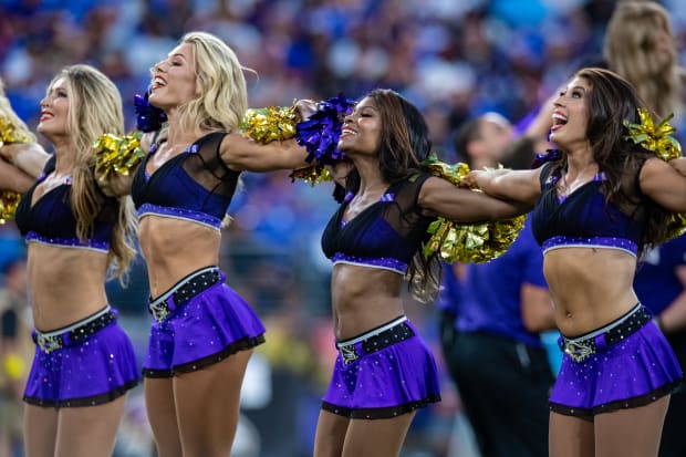 Photo: A Packers cheerleader waves pom poms against the Ravens in