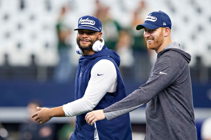 Dak Prescott and Cooper Rush warm up on the field.