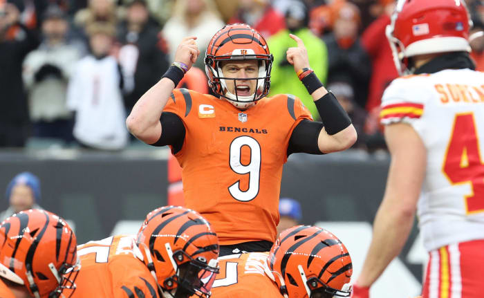 Cincinnati Bengals quarterback Joe Burrow points at his helmet with both hands before snapping the ball.