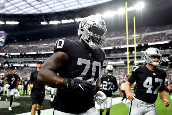 Raiders offensive lineman Alex Leatherwood jogs into the locker room.