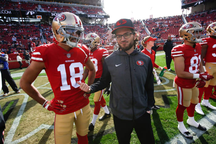 Mike McDaniel talks with 49ers players during pregame.
