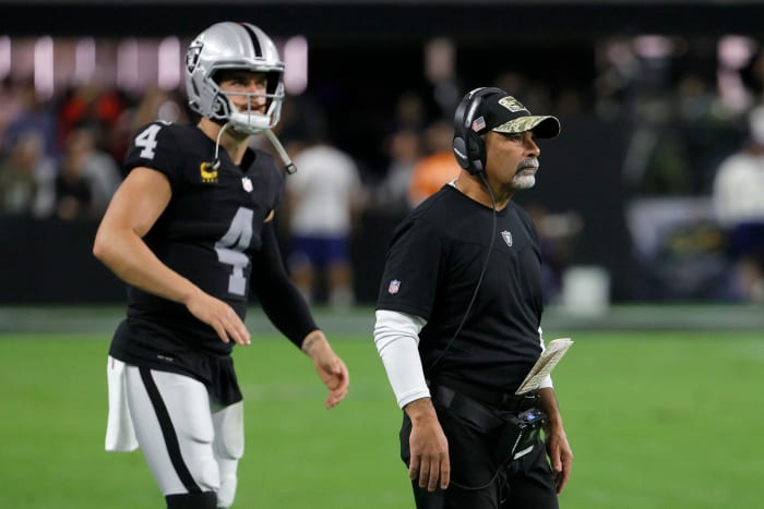 Derek Carr walking alongside interim head coach Rich Bisaccia.