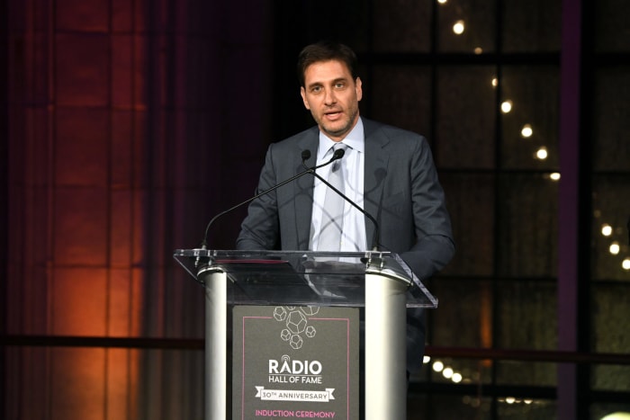 ESPN host Mike Greenberg speaking on stage.
