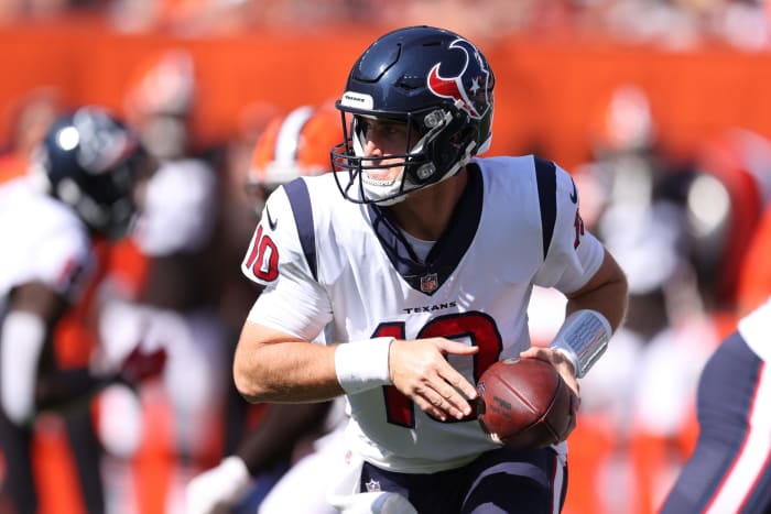 Texans quarterback Davis Mills hands the ball off in a game.