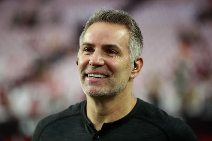 Kurt Warner looks on and smiles.