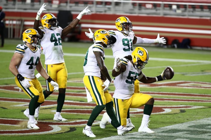Green Bay Packers defenders including Za'Darius Smith celebrate a play.