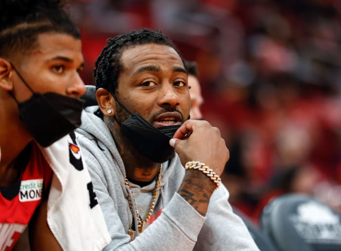 Rockets guard John Wall sits on the bench during a game.