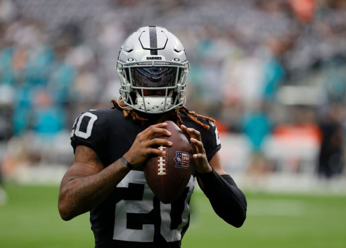 Raiders cornerback Damon Arnette holding a football before the game.
