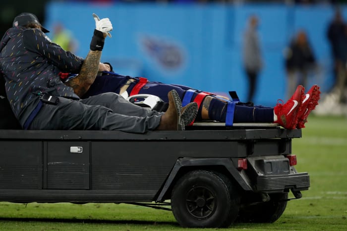 Tennessee Titans left tackle Taylor Lewan gives a thumbs up as he's carted off the field with a head injury.