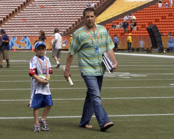 A picture of Sean Payton and his son walking across the field at the Pro Bowl.