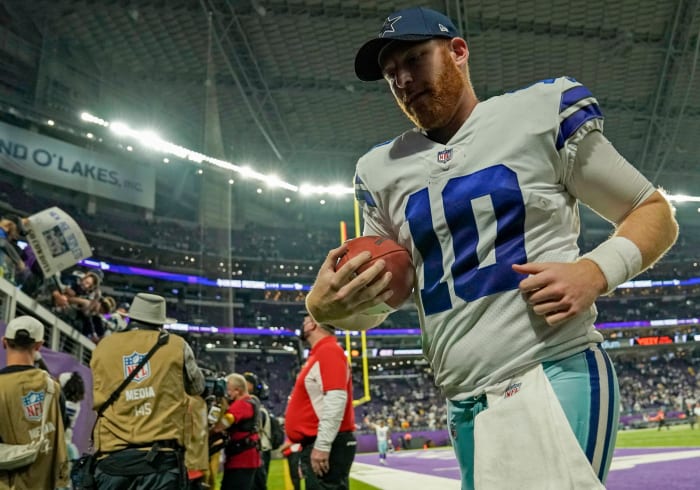 Cowboys quarterback Cooper Rush runs off the field.
