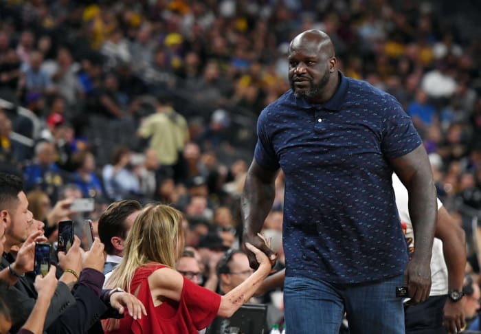 Shaq shaking hands with a fan.