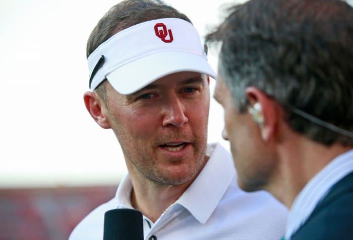 A closeup of Lincoln riley talking to the media after a football game.