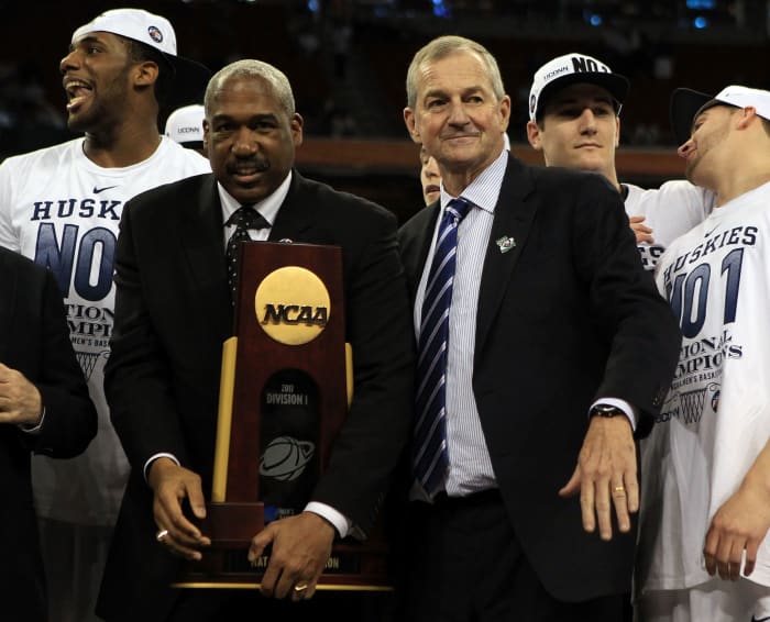 Gene Smith handing a trophy over to Jim Calhoun.