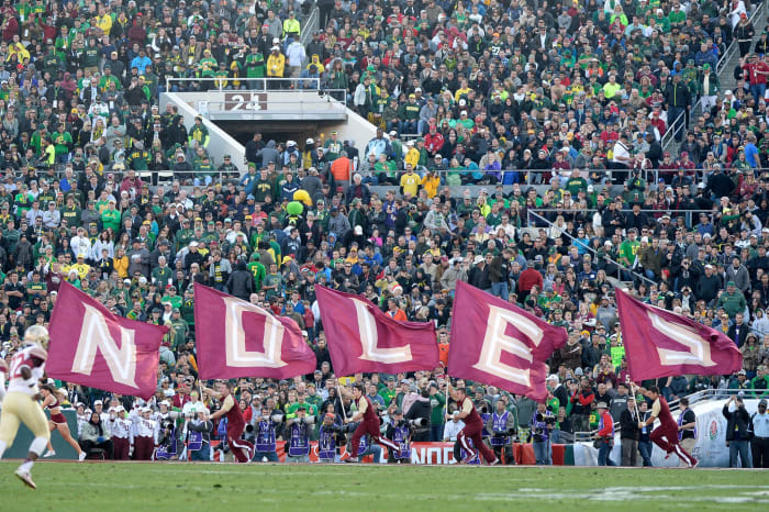 Florida State cheerleaders run with flags that spell out NOLES.