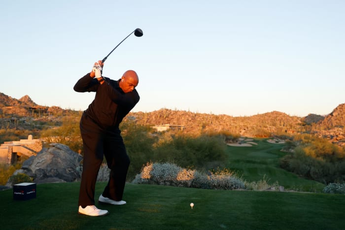 Charles Barkley mengayunkan tongkat golf.