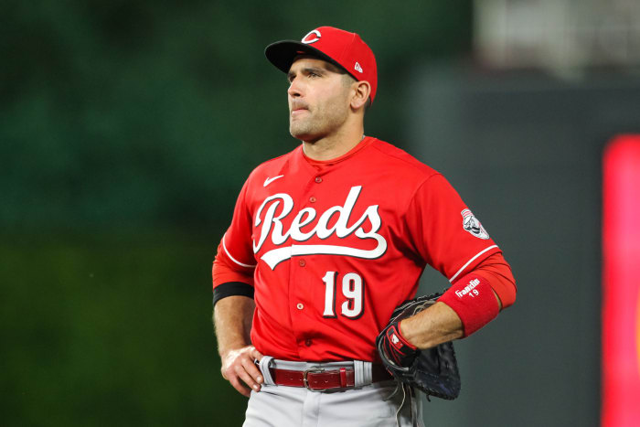 Joey Votto stands in the field with his hands on his hips.