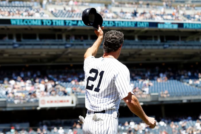 Paul O'Neill, wearing No. 21, tips his cap to the crowd at Yankee Stadium.