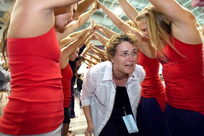 Cal swimming head coach Teri McKeever walks through a tunnel of Arizona swimmers.