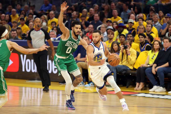 Steph Curry drives to the basket with Jayson Tatum guarding him.