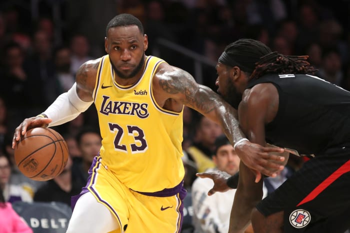 LeBron James dribbling past Montrezl Harrell during a game.