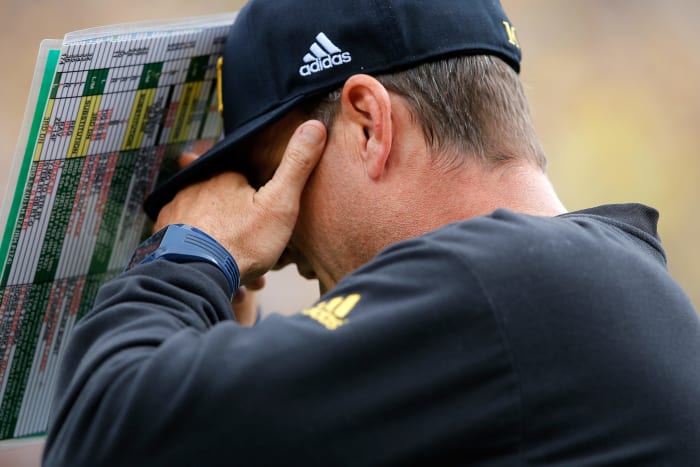 A closeup of Jim Harbaugh looking upset during a Michigan football game.