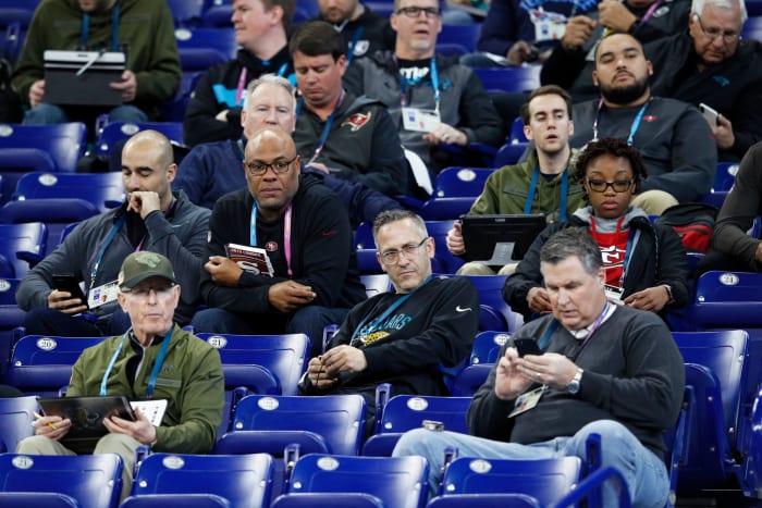 a group of nfl coaches and scouts at the nfl combine