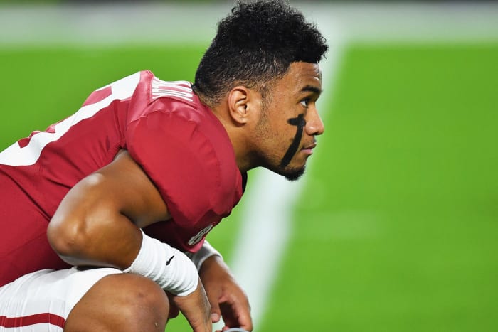 A closeup of Tua Tagovailoa crouching on the football field.