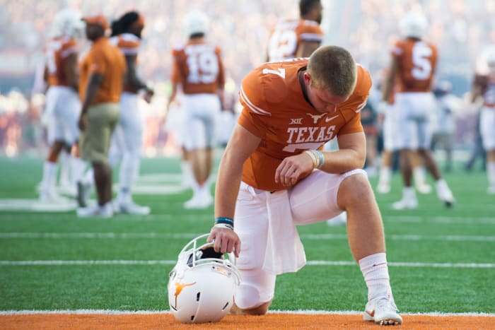 Texas Longhorns QB Shane Buechele kneeling in the end zone.