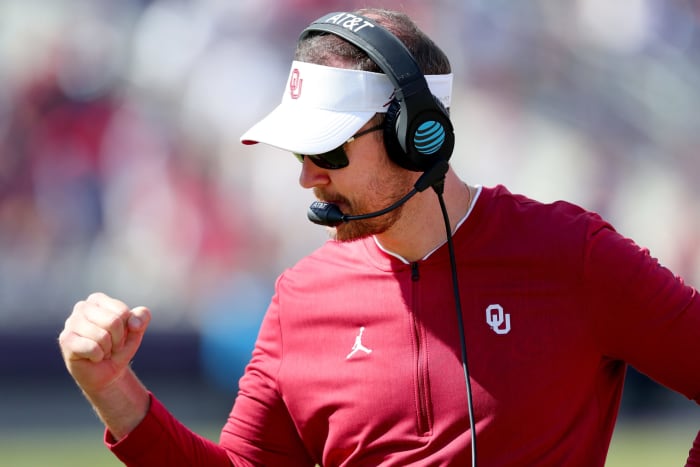 A closeup of Oklahoma football coach Lincoln Riley pumping his fist.