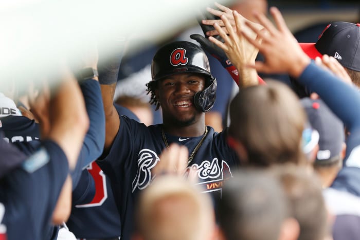 Ronald Acuna Jr. slapping hi-five with his teammates.