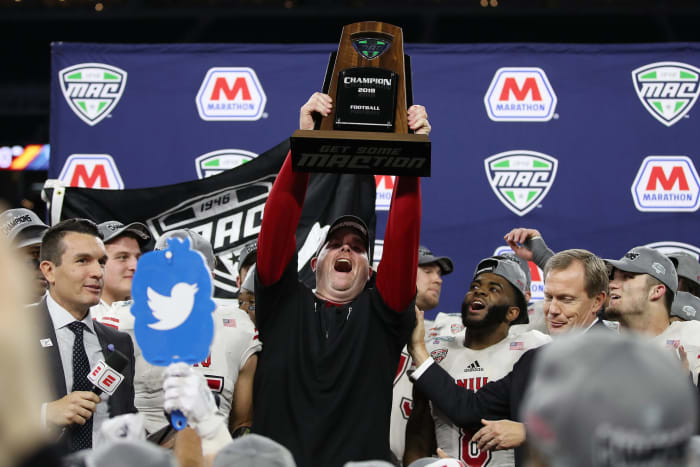 Rod Carey lifts MAC football championship trophy.