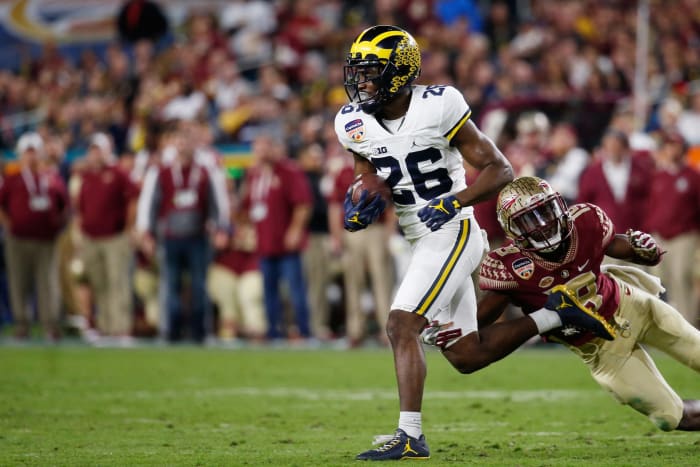 Jourdan Lewis of the Michigan Wolverines tries to avoid the tackle of Carlos Becker III #15 of the Florida State Seminoles.