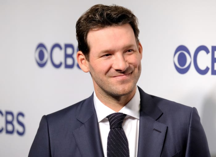 Tony Romo standing in front of a CBS banner.