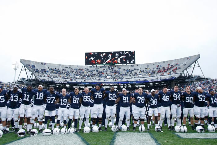 Penn State players locking arms.