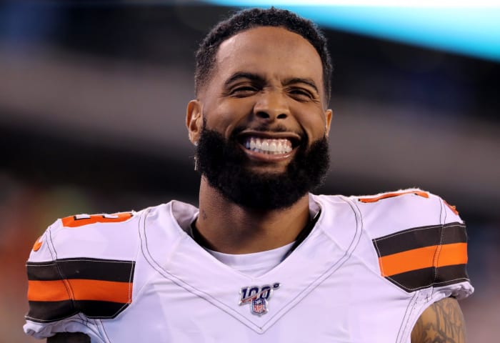 Odell Beckham Jr. smiles on the field before a game.
