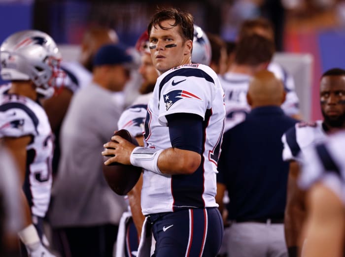 Tom Brady throwing passes on the sideline.