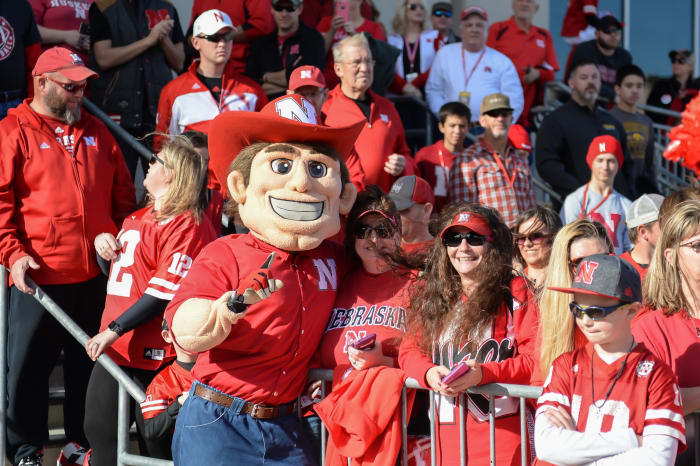 The Nebraska football mascot celebrates with fans in the stands against Iowa.