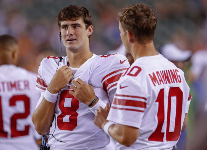 Daniel Jones and Eli Manning talking on the sidelines.