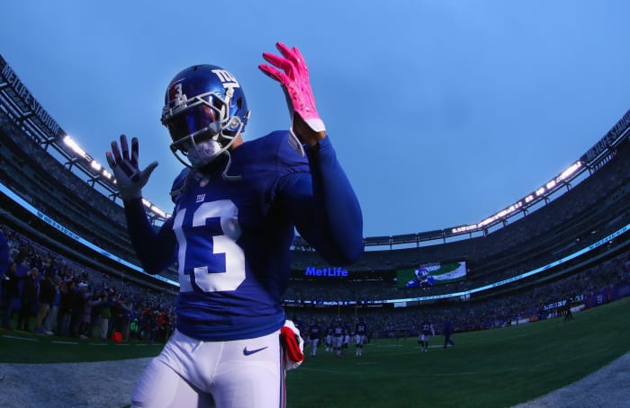 Odell Beckham Jr. running off the field with his hands up.