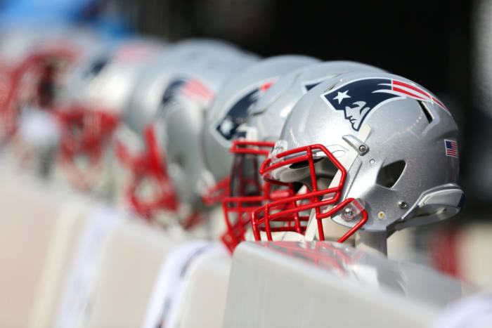 A New England Patriots helmet sitting on the bench.