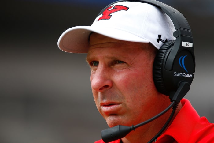 Bo Pelini wearing a headset on the sideline,