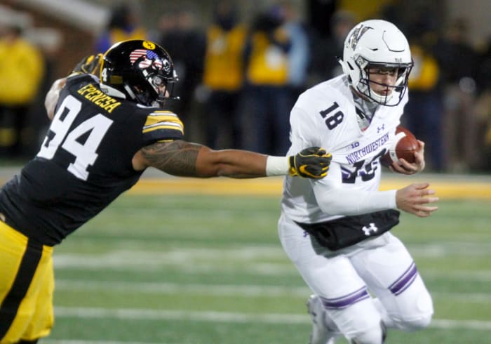 Iowa's A.J. Epenesa reaches for Northwewstern's Clayton Thorson.