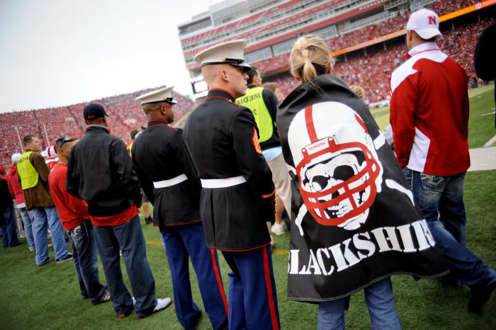 A Nebraska football fan wraps herself in a Blackshirts flag.