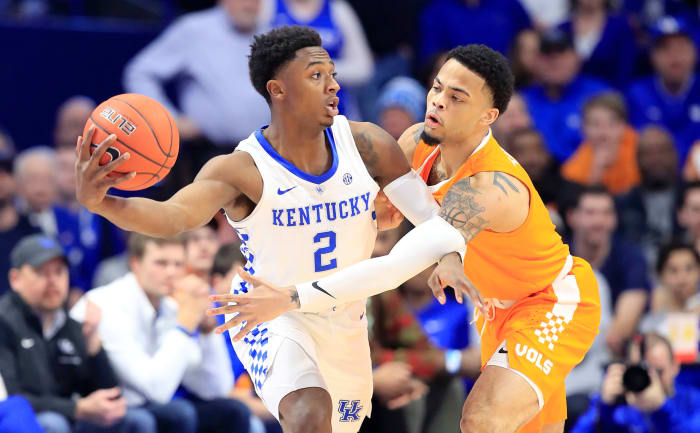 Ashton Hagans passes the ball around a Tennessee player.