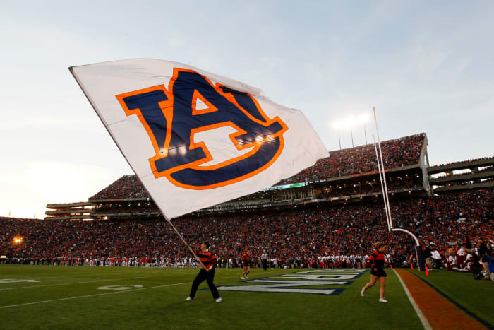 An Auburn supporter waves the flag on the field for the Tigers.