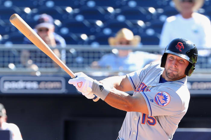 Tim Tebow swinging a baseball bat.