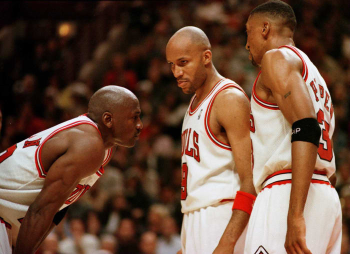 Michael Jordan talks with Scottie Pippen and Ron Harper during a game.